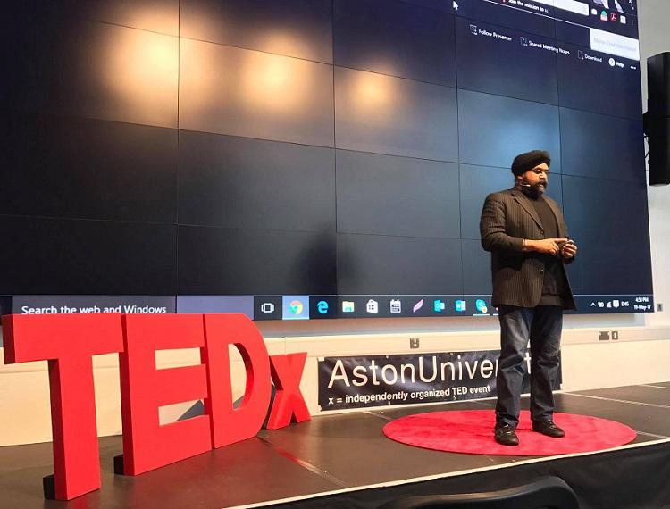 Sukhi Wahiwala on stage during his TEDx talk at Aston University