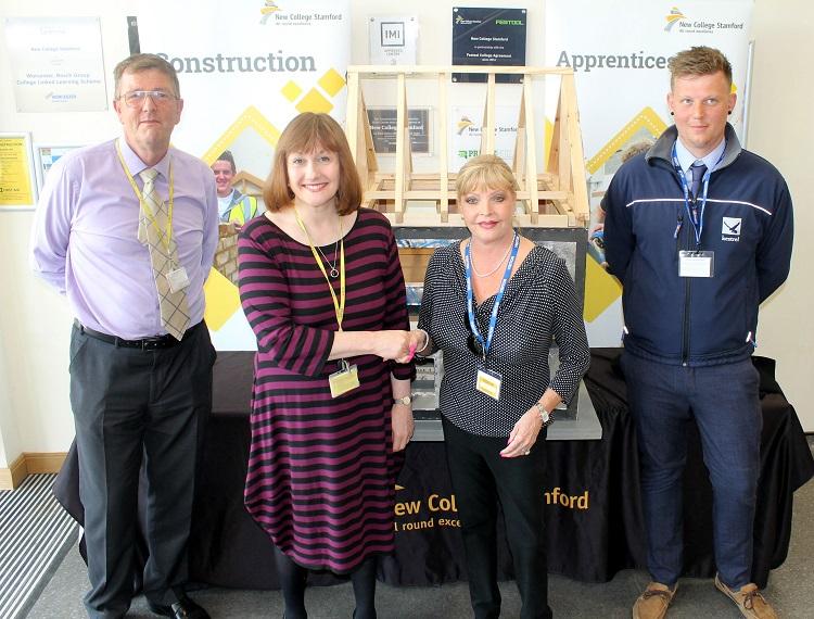Richard Brickwood, head of construction at New College Stamford (left), and college principal Janet Meenaghan accept the model house from Helen Hick, joint managing director of Larkfleet Homes (centre) and Karl Barfoot (right) from Kestrel Timber Frame which built the model.