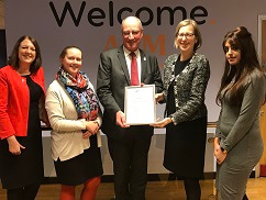 New Disability Minister, Sarah Newton (centre), presents APM Chief Executive, Alan Cave (centre) and APM employees, with a Disability Confident Leader Award.