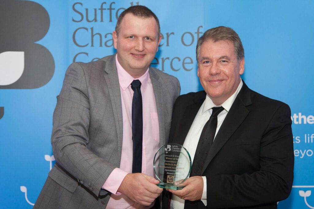Adam Noble from Pleasurewood Hills (left) receives the trophy from John McNamara of Sizewell C, which sponsored the Commitment to Skills & Staff Development Award. Photo courtesy of Ferini Media
