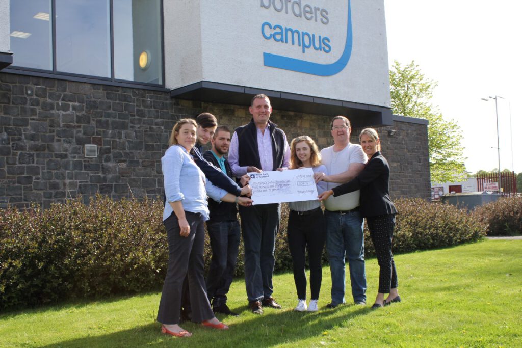 Doddie Weir pictured receiving the cheque donation from Borders College students and lecturers involved in the fundraising event.
