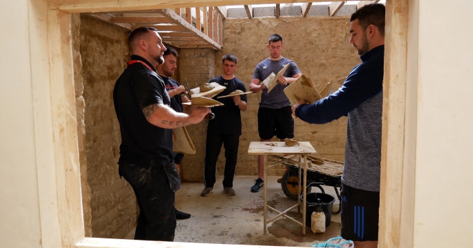 Ospreys squad members learning the basics of plastering at Neath College.