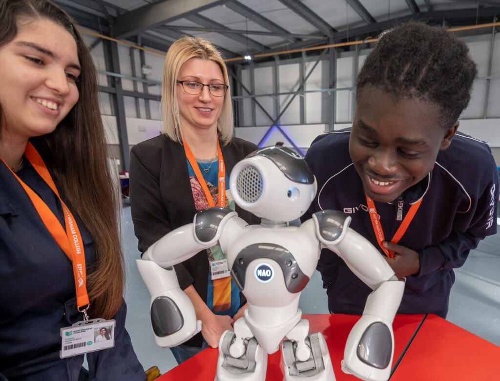 l-r Engineering students Fiorella Di Marco, 18, Anna Maroz, 34, and Kojo Amuzu, 19, with the NAO robot in the STEM Centre