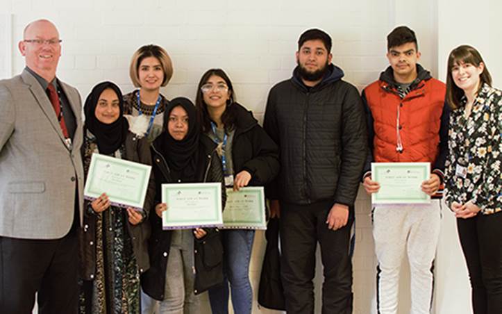 Photo shows Bradford College CEO Chris Webb (left) and Lauren Pickles, Enrichment and Engagement Officer (right) with students collecting their certificates.