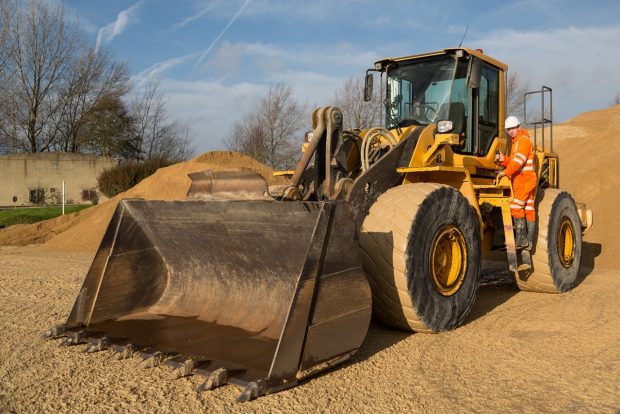 An apprentice Mineral Processing Mobile and Static Plant Operator standing next to mobile heavy plant vehicle