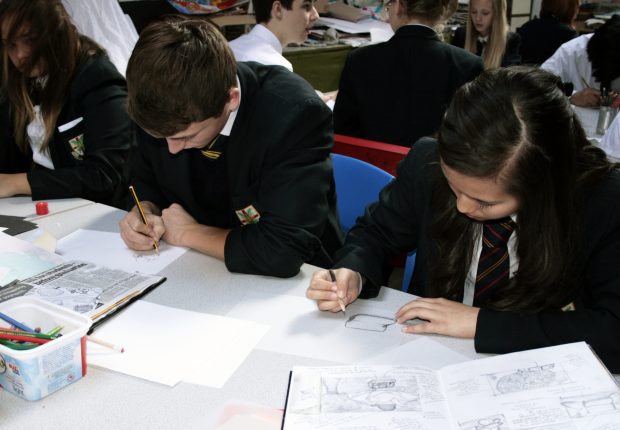pupils writing in workbooks