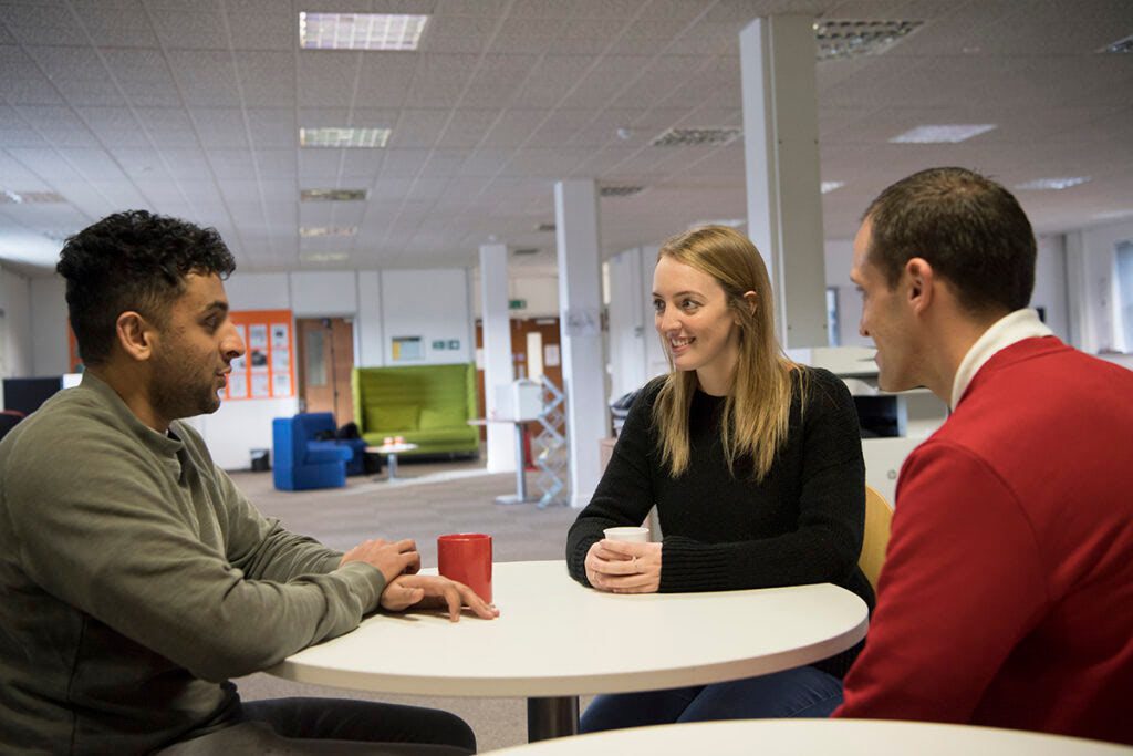 People chatting around an open plan office table