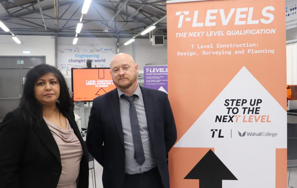 Two people standing under a T Levels sign