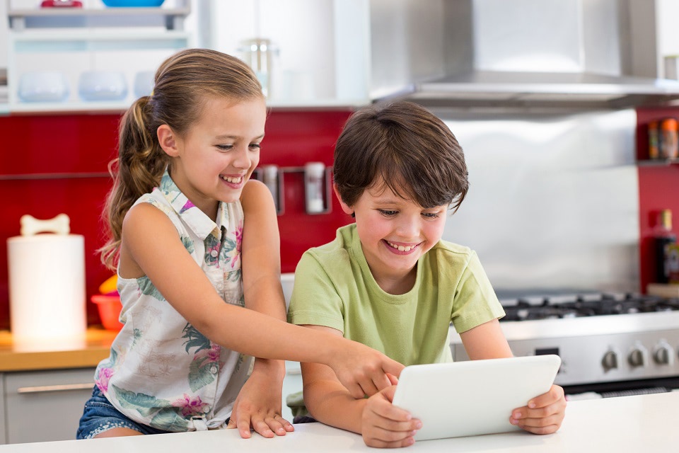 Happy siblings using table in the kitchen