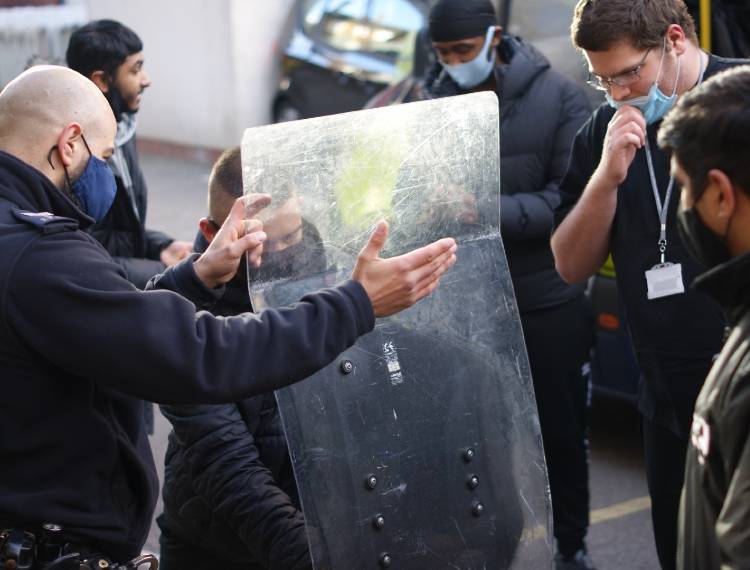 Students learning how to use a riot shield