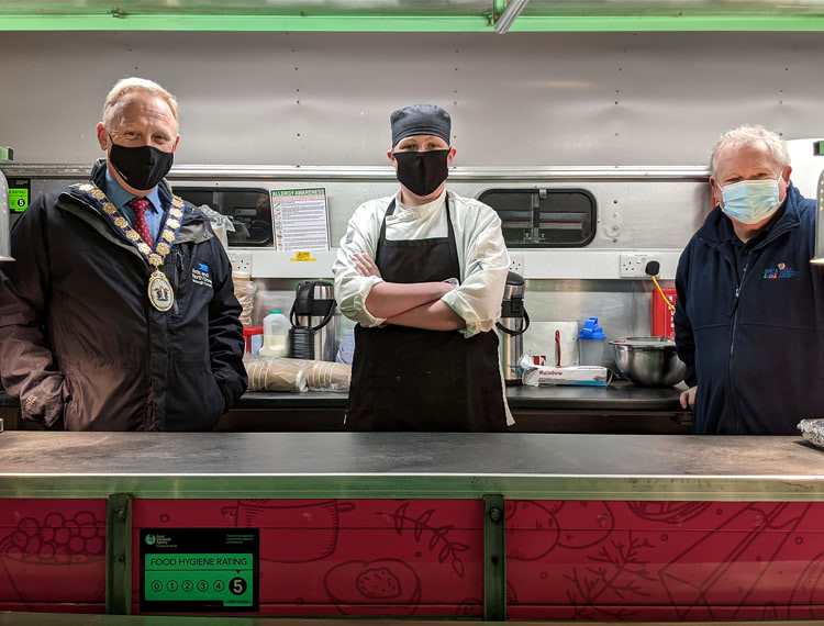 Food bank and three people in masks for the food truck