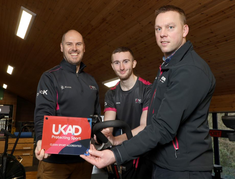 three people holding an award