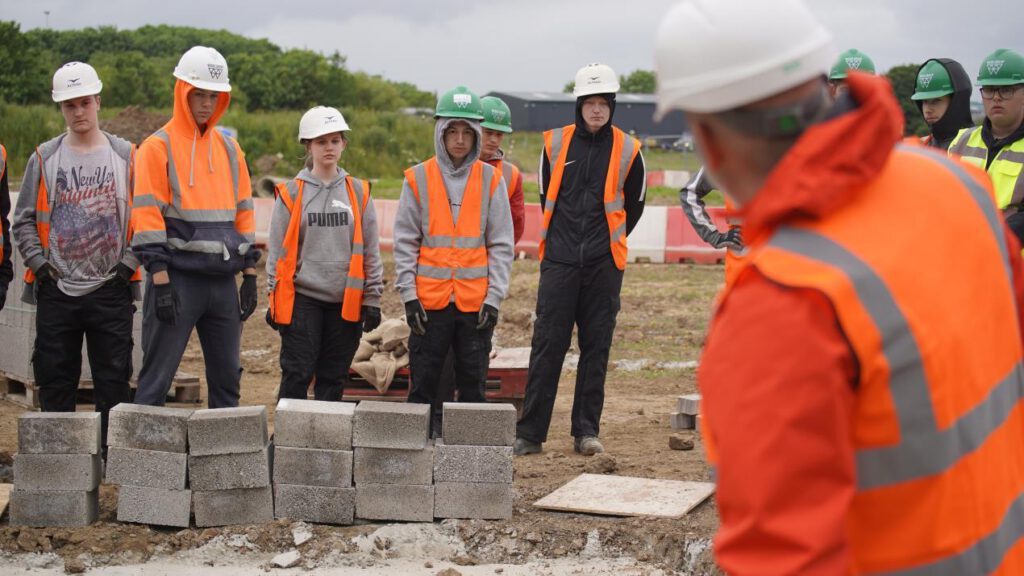 John Cartwright on site with bricklaying students