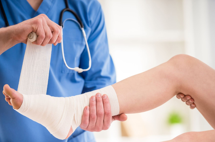 Medical professional dressing an ankle injury