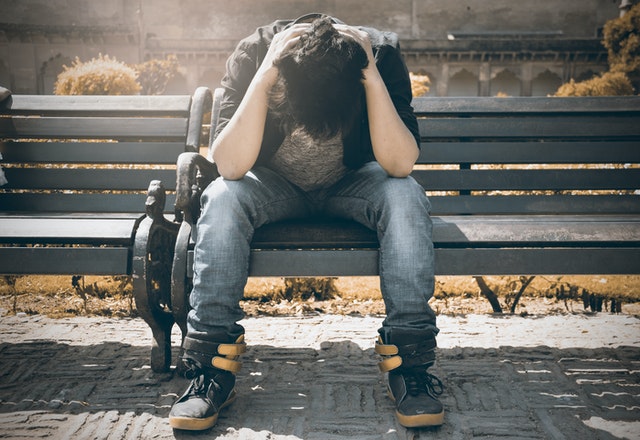 Young person alone on a park bench