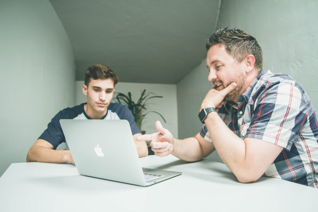 Two people working on a laptop