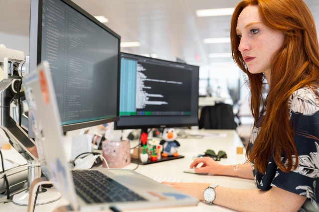 lady working at her desk with multi-screen