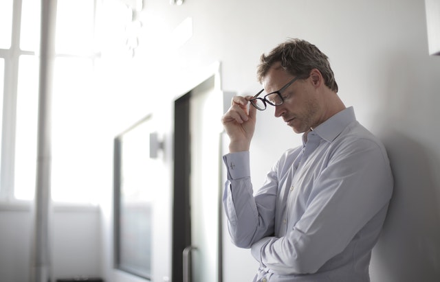 Stressed out worker holding their glasses