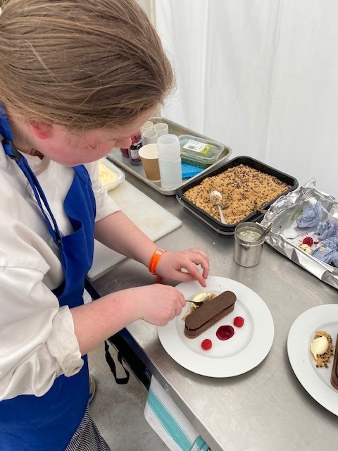 Catering and Hospitality student, Trinity Wilson, preparing food at the festival.