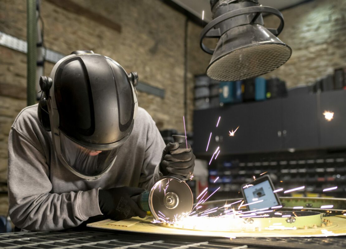 Person using machinery and sparks flying