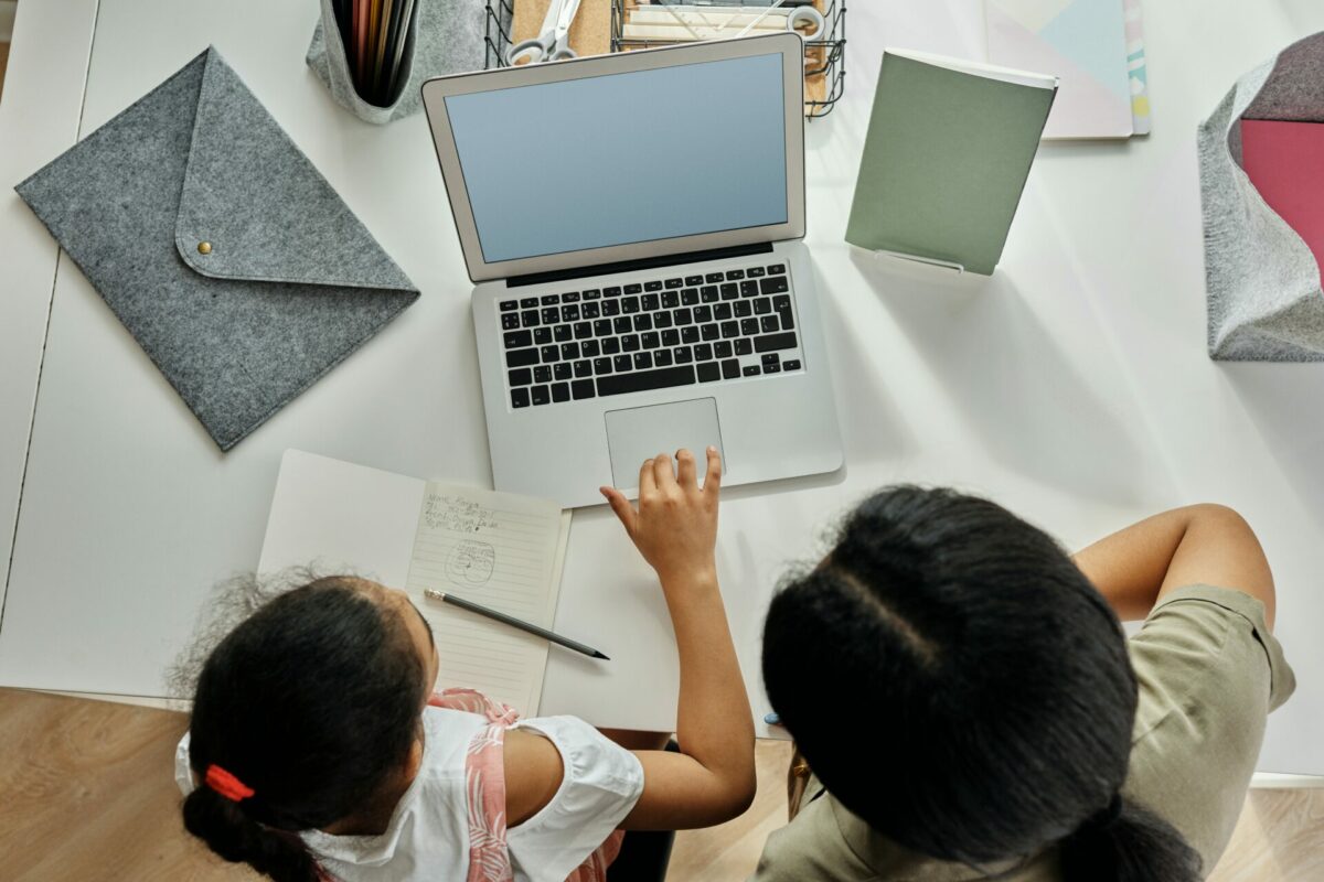 Child with adult on laptop