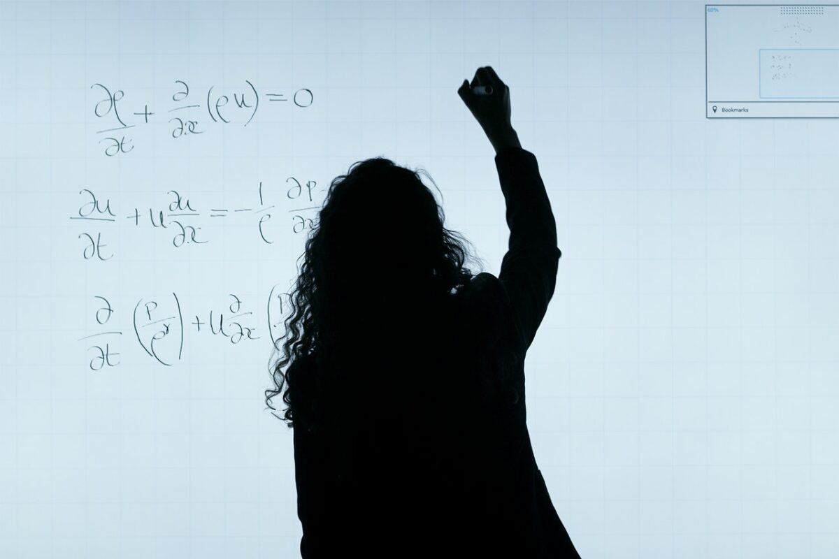 Woman silhouette writing maths on whiteboard
