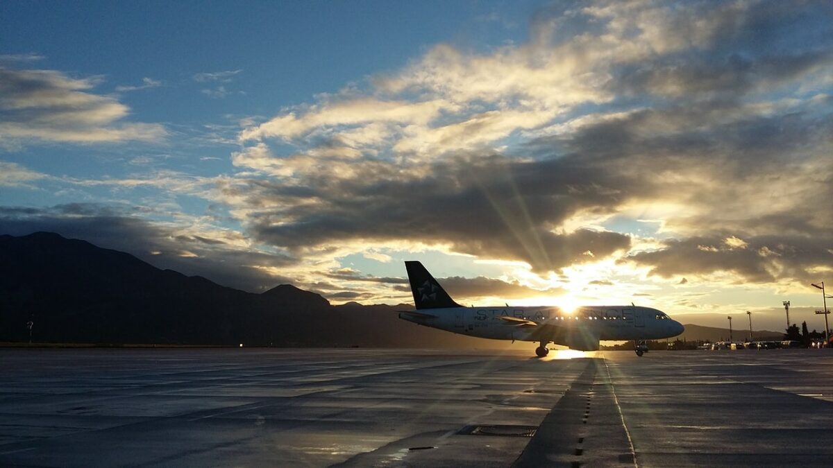 Plane on runway with sun behind it