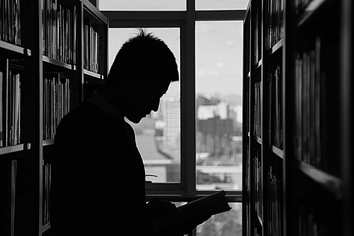 silhouette of person reading book