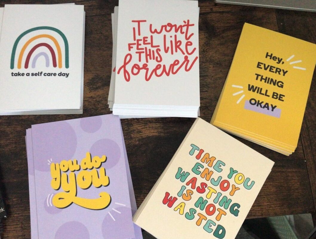 Images of affirmation cards used by Student Roost and designed by students. One reads: Take a self care day. Another reads: It won't feel like this forever. Another says: Hey, everything will be okay. Another says: You do you. The final card reads: Time you enjoy wasting is not wasted.