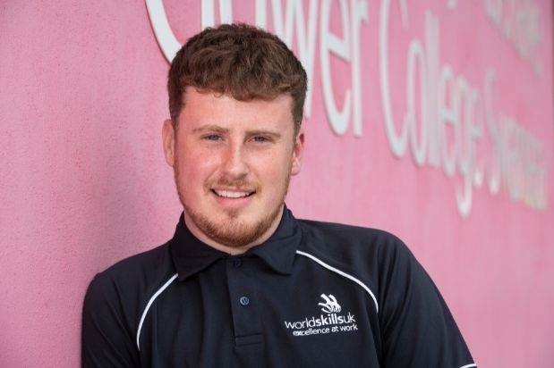 Ben in his WorldSkills UK shirt outside Gower College Swansea's Tycoch Campus