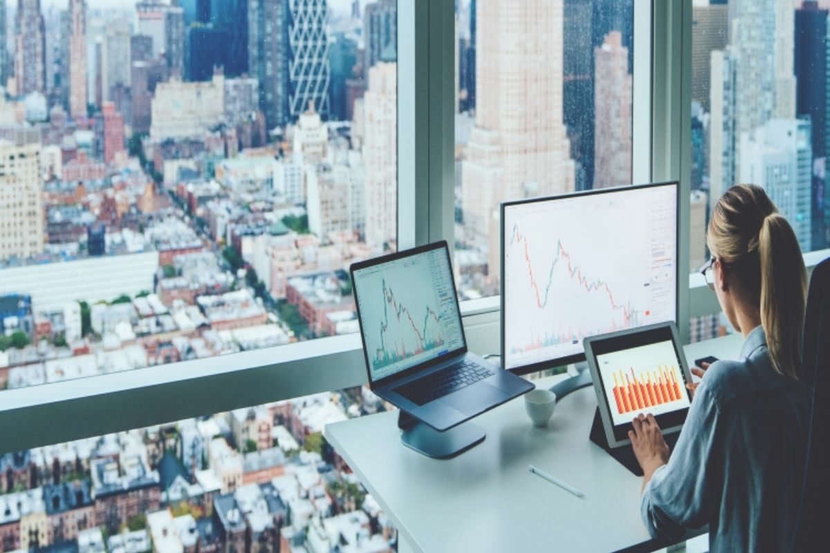 female sat at desk with cityscape view in front of her