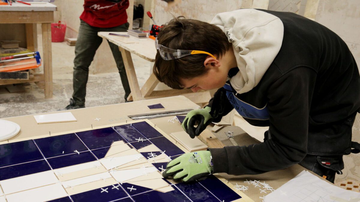 Student Aaron Brady tiling in the 2021 SkillBuild national competition final.