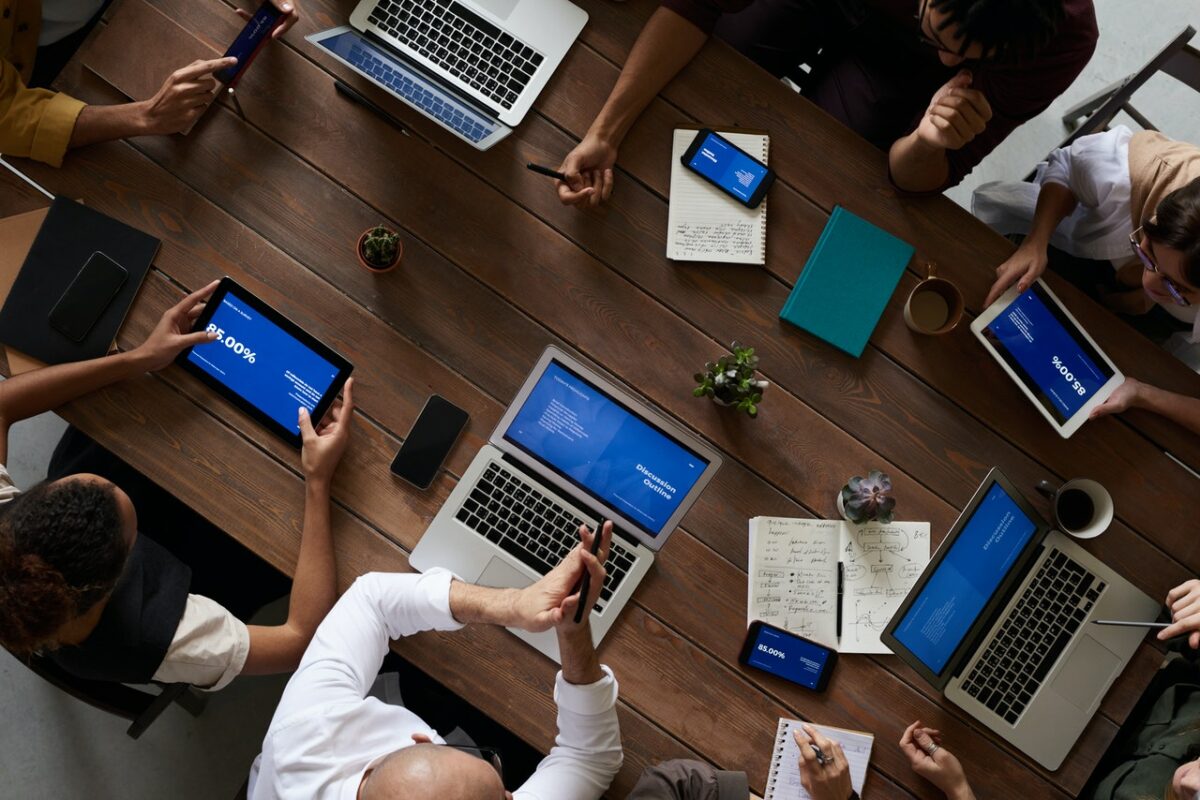 People with laptops sat around table