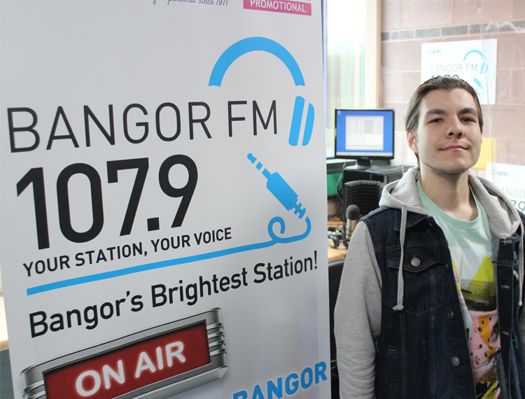 Scottie Watters beside a Bangor FM sign