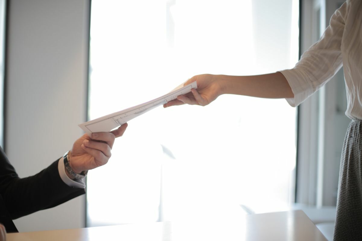 hands passing piece of paper