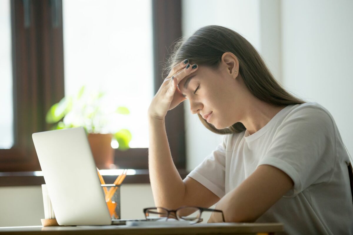 Student with her head in hands at a computer