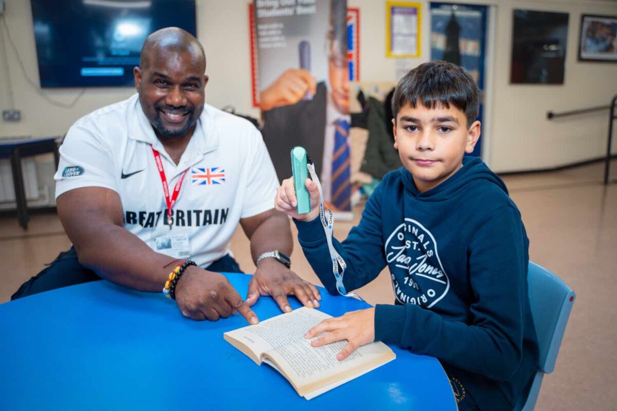 Kevin Brown shows Akeem Sayed from Boldmere Junior School how to use the OrCam Learn