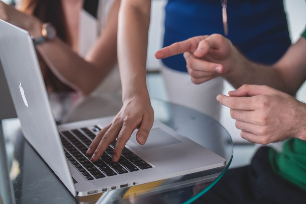 people looking and pointing at laptop