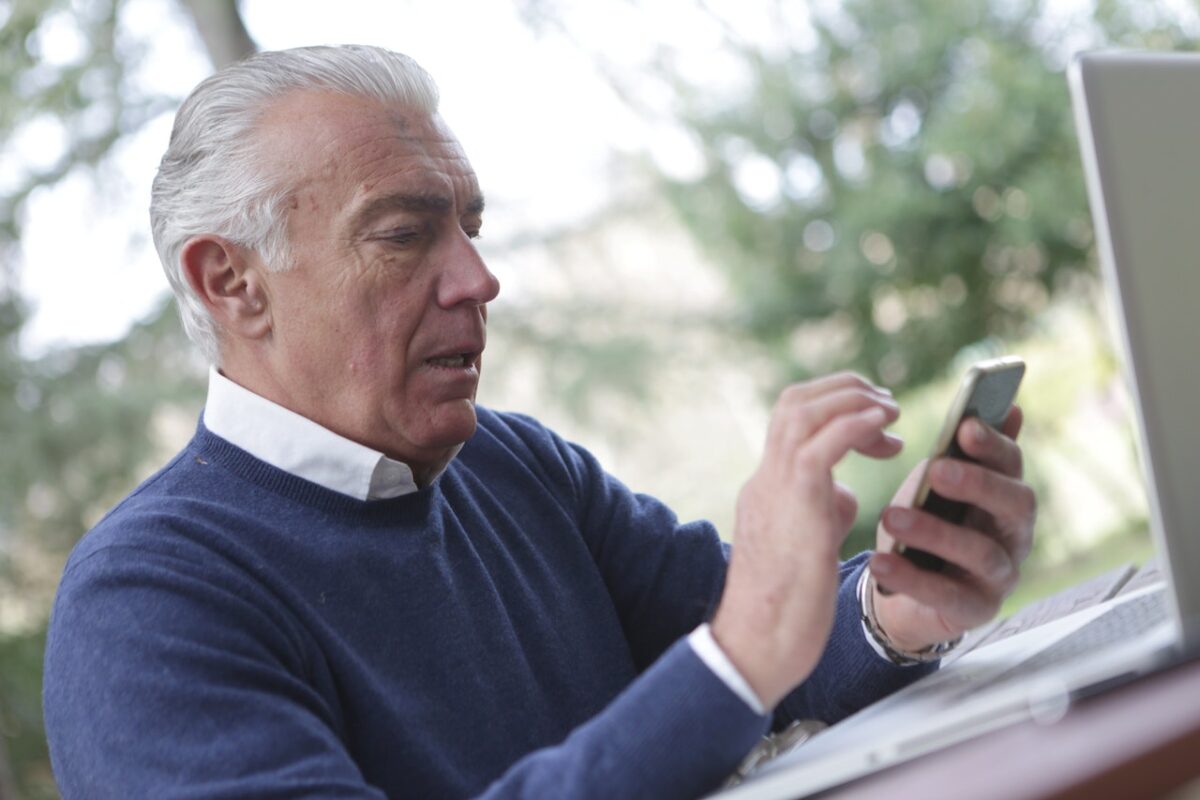 older person on laptop and phone