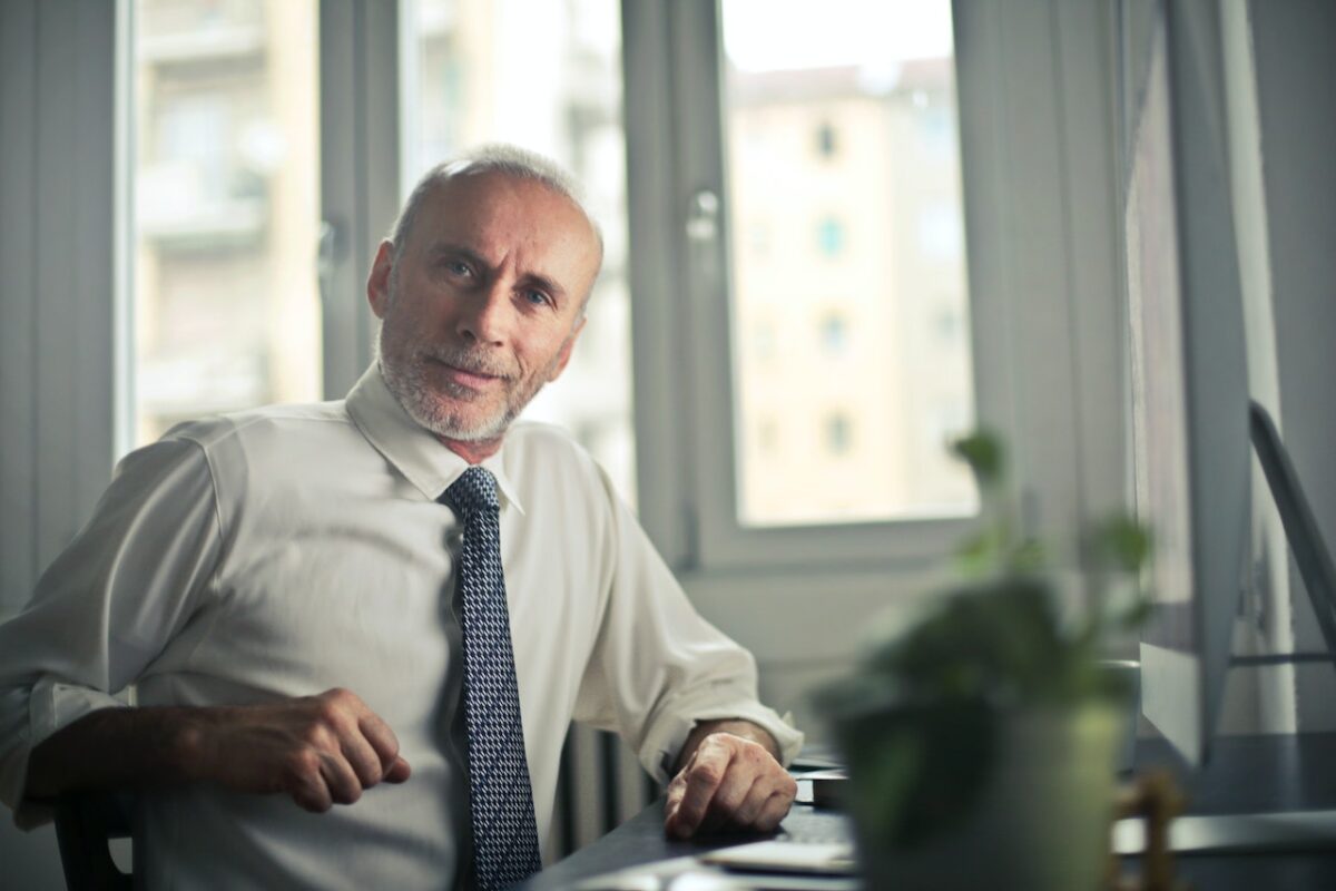 older man sat at desk