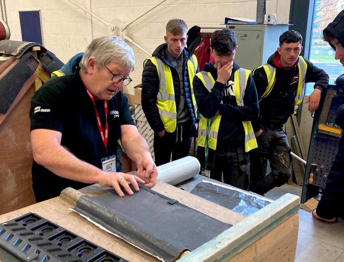 Three Leeds College of Building roofing students watch a roofing demonstration by a member of the Glidevale Protect team.