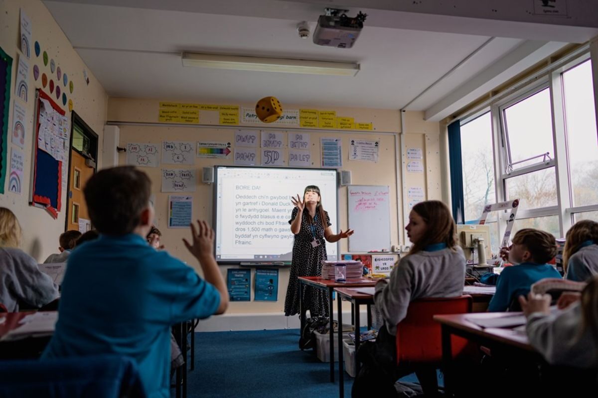 Teaching in a classroom, teacher and a class of pupils