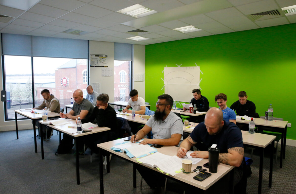 A group of male students studying electrical training sit in a classroom at Leeds College of Building.