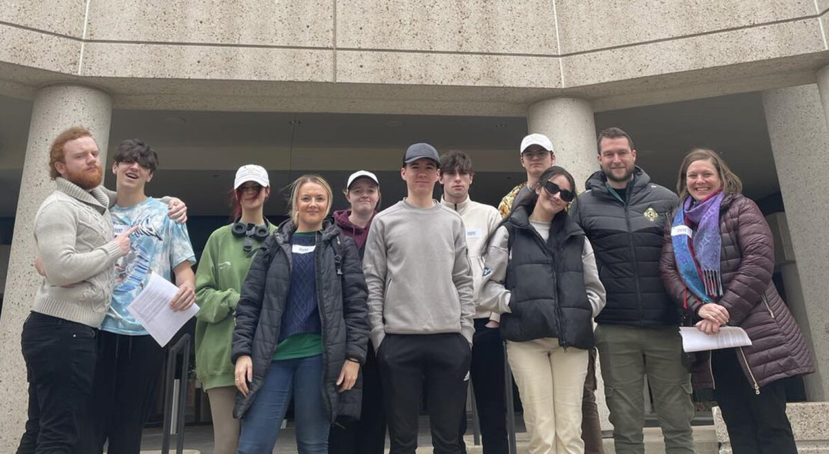 A group of students with their lecturea and guide pose outside BMI buildings in Nashville