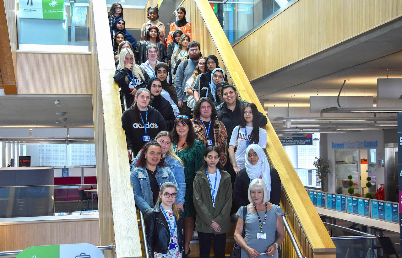 Bradford College staff and Fast Track to T Level Health students who took part in the virtual ‘Aspiring Allies’ project pose on a modern staircase inside the campus building.