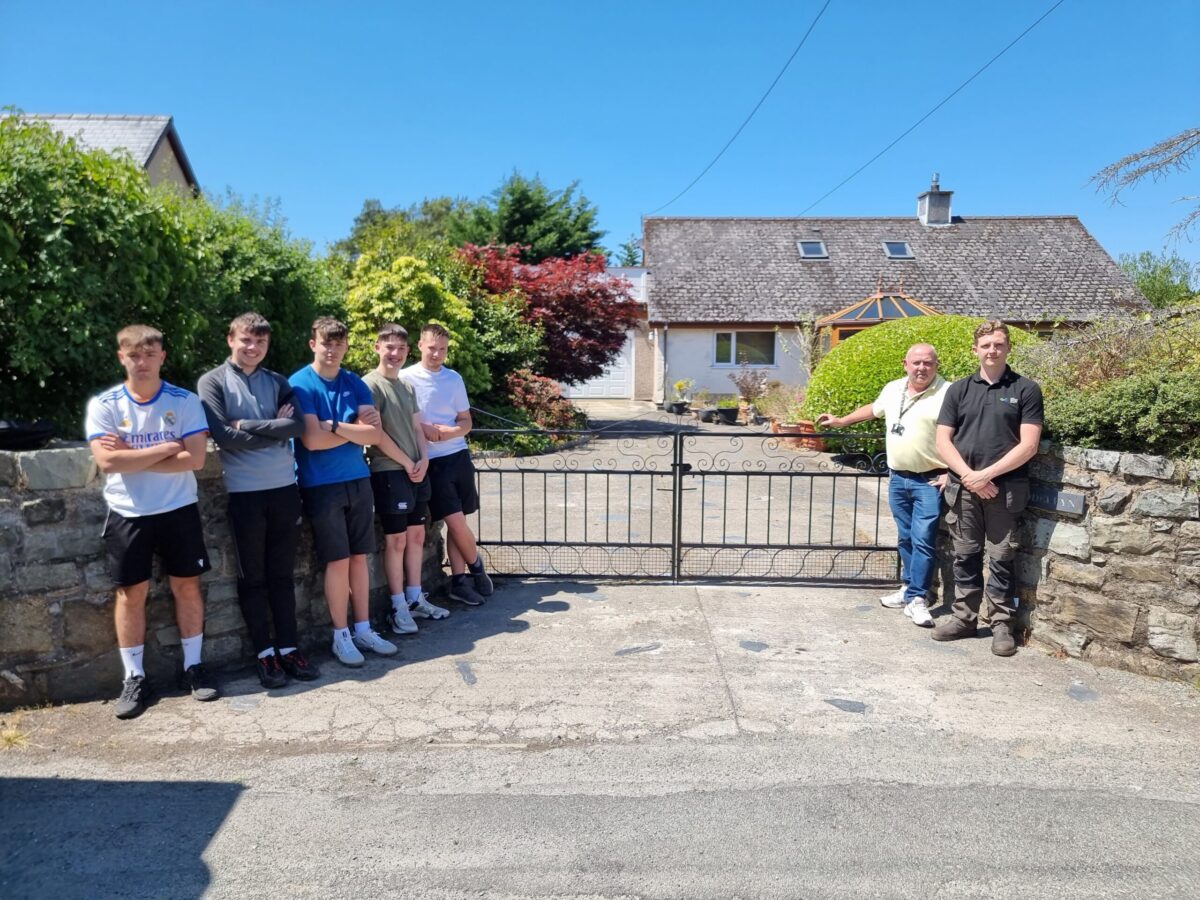 Left to right: Students Cian Pritchard, Kevin Evans, Caio Morgan, Cian Jones and Huw Jones and tutors Gwyn Williams and Tom Allday with the gate