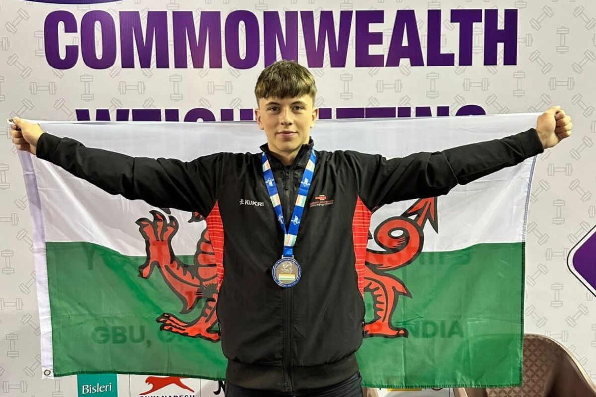 Cian Green celebrates with the Wales flag after winning silver in Delhi