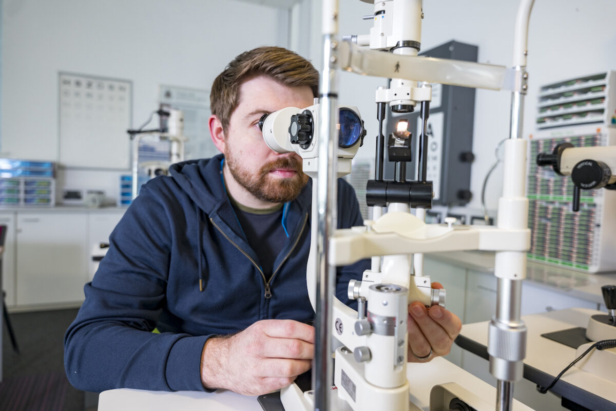 Bradford College ophthalmic dispensing student uses equipment to train in the college.