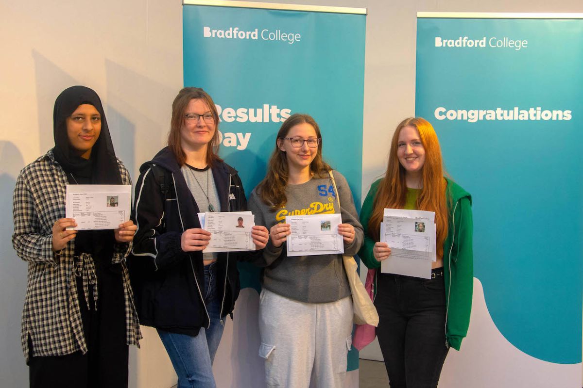 A group of four female Bradford College students pose with their A Level certificates.