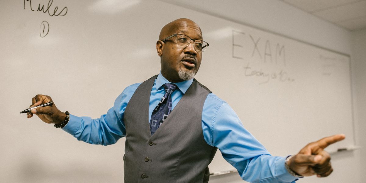 Black teacher at white board